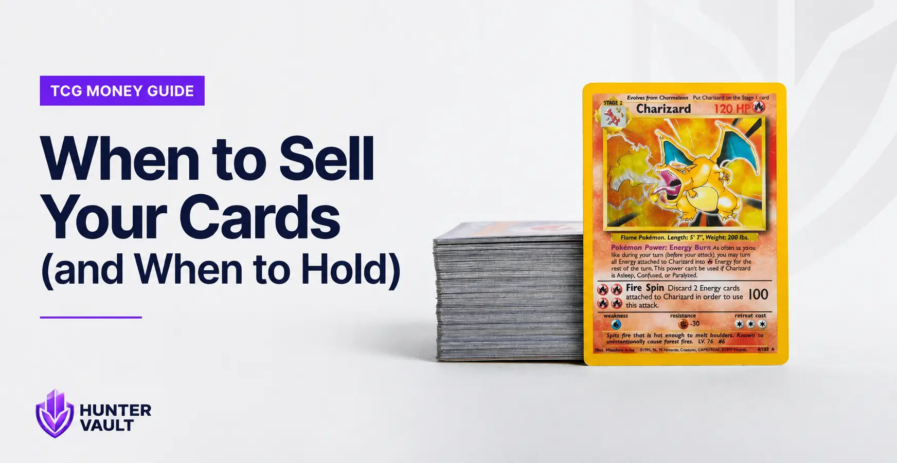 Trading cards laid out on a table with price charts visible on a laptop screen in the background